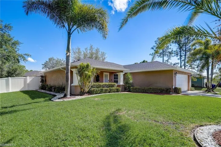Single story home featuring an attached garage, stucco siding, and driveway