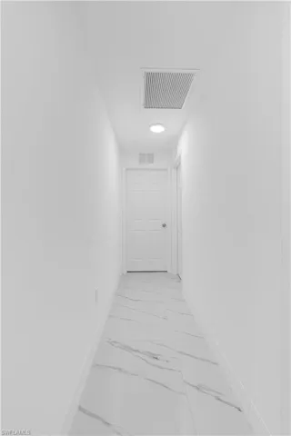 Hall with light marble finish floors and baseboards