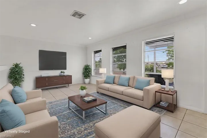 Living area featuring recessed lighting, crown molding, visible vents, and light tile patterned flooring
