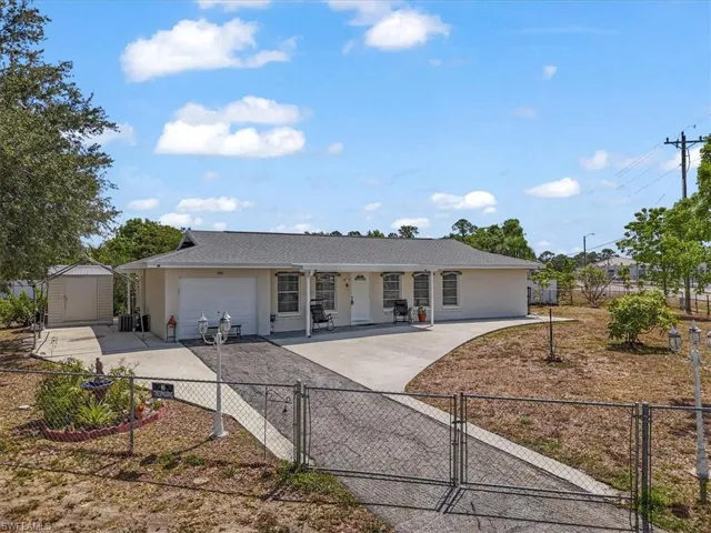 Single story home with a shed, a fenced front yard, a garage, concrete driveway, and a gate