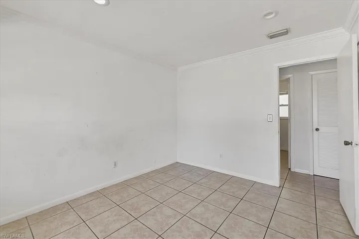 Spare room with ornamental molding, light tile patterned flooring, visible vents, recessed lighting, and baseboards