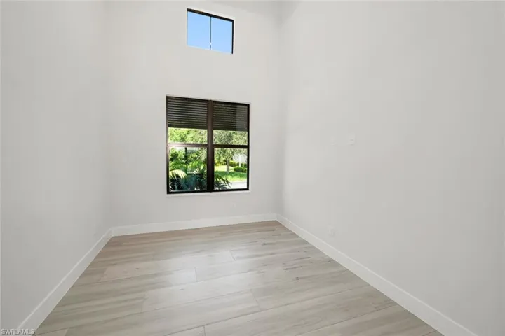 Den/Office featuring 15' high ceiling and light wood-type plank flooring.
