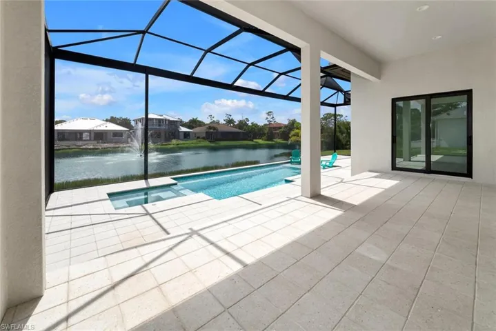 View of pool featuring a patio, a water view, pool water feature, and a lanai