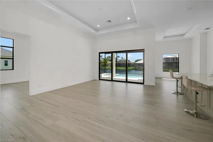 Open Great room with tray ceiling, accent lighting and adjoining Dinning room.