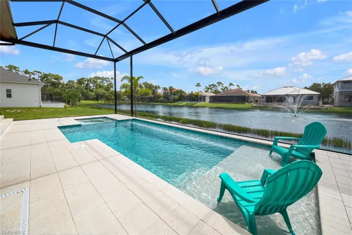View of swimming pool with a patio, a water view, pool water feature, and a lanai