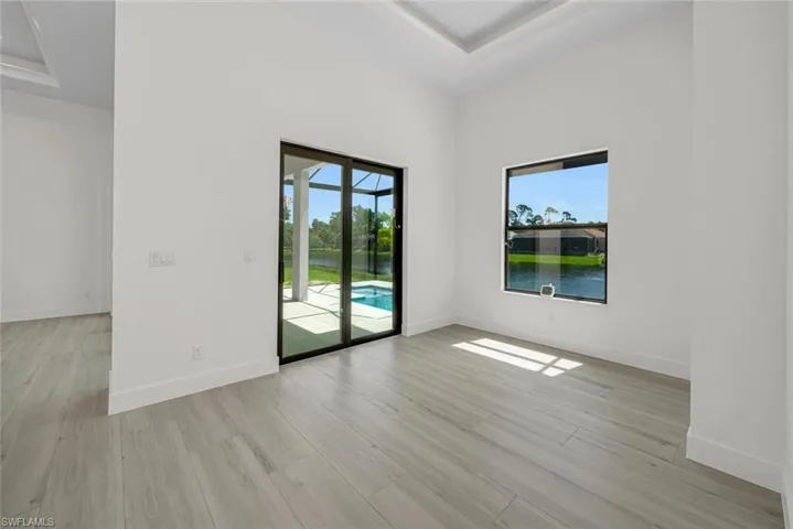 10'-10" x 12'-2" Dining room featuring 13' tray ceiling, Lanai slider with a beautiful pool and water fountain lake view.