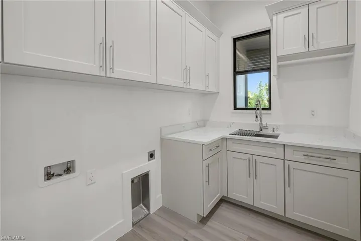 Laundry room with cabinets, sink, light hardwood / wood-style flooring, and hookup for a washing machine