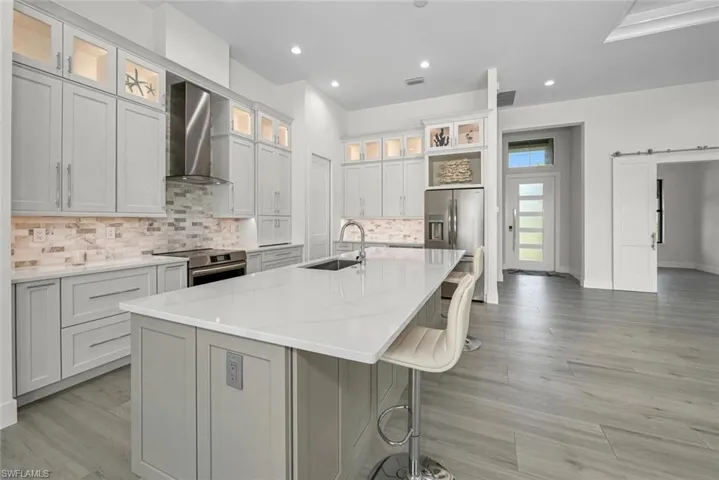 Designer Kitchen with Monagram stainless steel appliances, large single bowl sink,custom marble backsplash, SS exhaust hood plus Pompeii Quartz island and countertops.