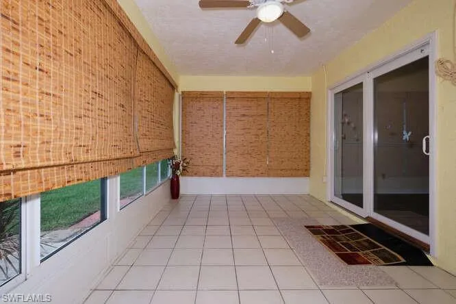 Unfurnished sunroom with ceiling fan
