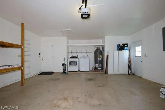 Garage with independent washer and dryer, a garage door opener, and water heater
