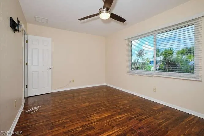 Unfurnished room featuring ceiling fan and dark hardwood / wood-style floors