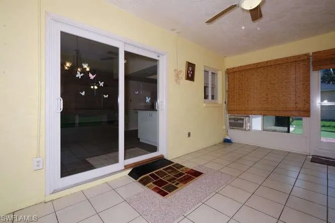 View of patio featuring a wall mounted AC and ceiling fan