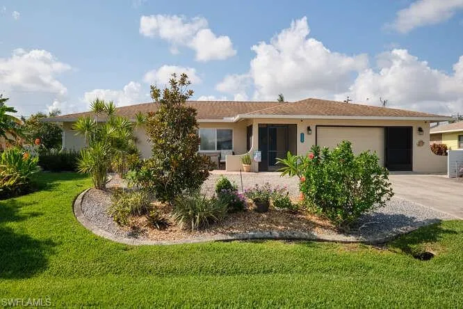 Ranch-style home featuring a front yard and a garage