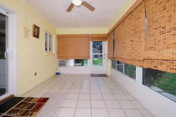 Unfurnished sunroom with ceiling fan