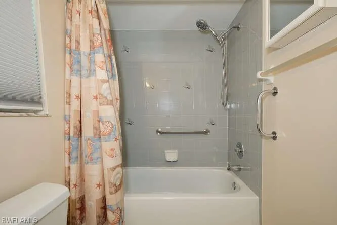 Bathroom featuring toilet and shower / tub combo