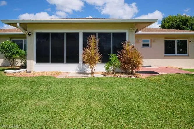 Rear view of property featuring a lawn