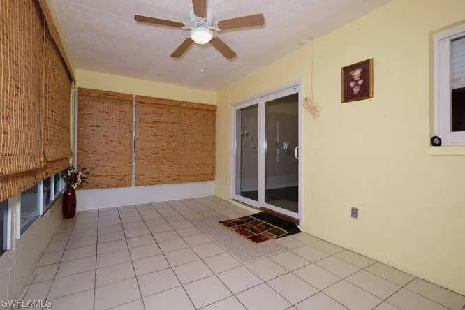 Unfurnished sunroom featuring ceiling fan