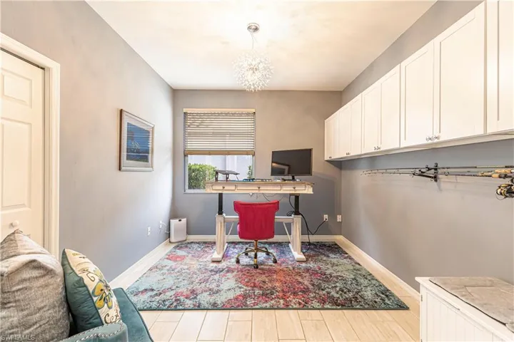 Third Bedroom/office space with light tile flooring, chandelier, and extra storage cabinets