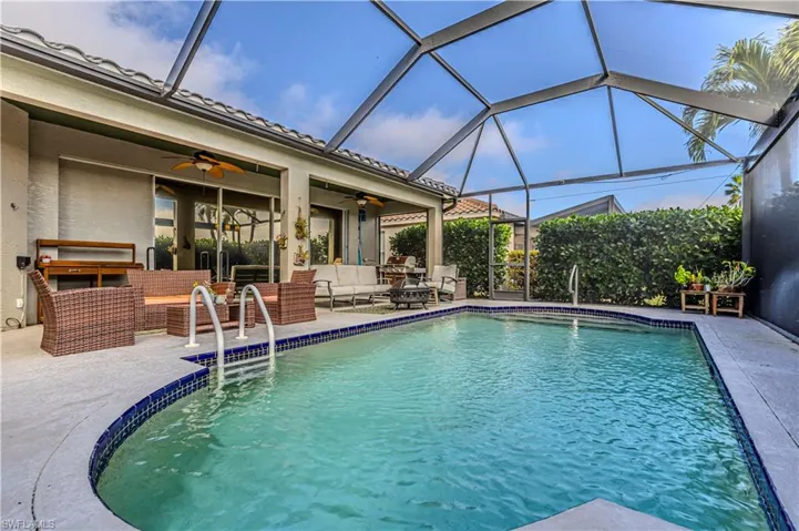 View of pool with an outdoor living space, lanai enclosure, and ceiling fan