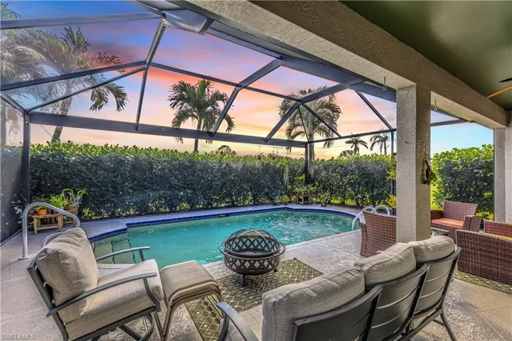 Pool at dusk. Large picture Screen Lanai with covered sitting area.
