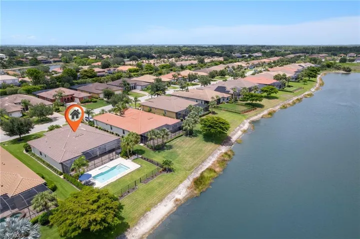 Aerial perspective of suburban area with a nearby body of water and a pool
