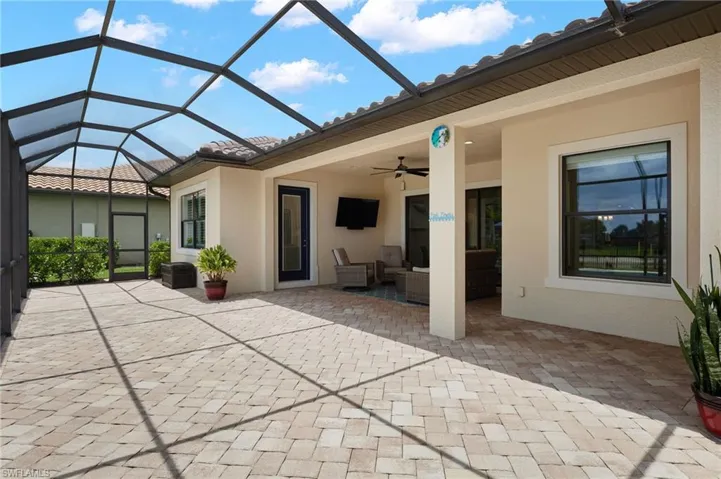 View of patio with a ceiling fan, an outdoor living space, and glass enclosure