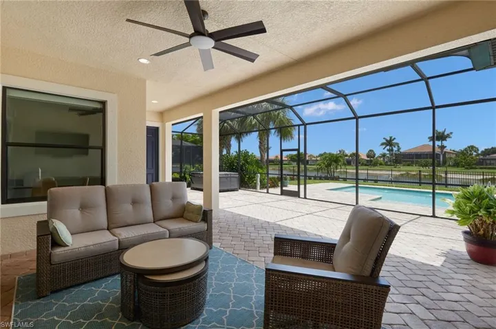 View of patio featuring a ceiling fan, an outdoor hangout area, and glass enclosure