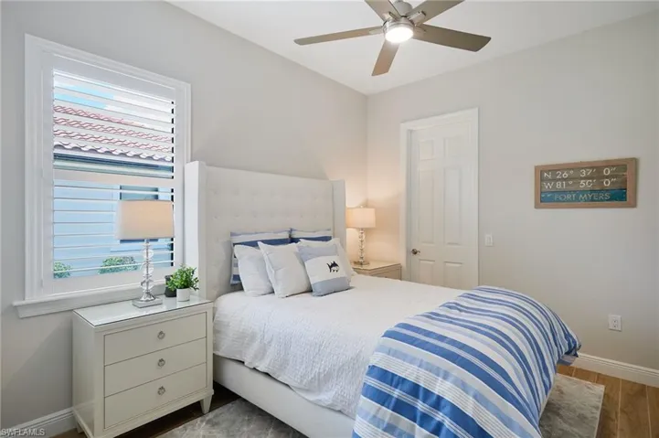 Bedroom with multiple windows, baseboards, wood finished floors, and ceiling fan