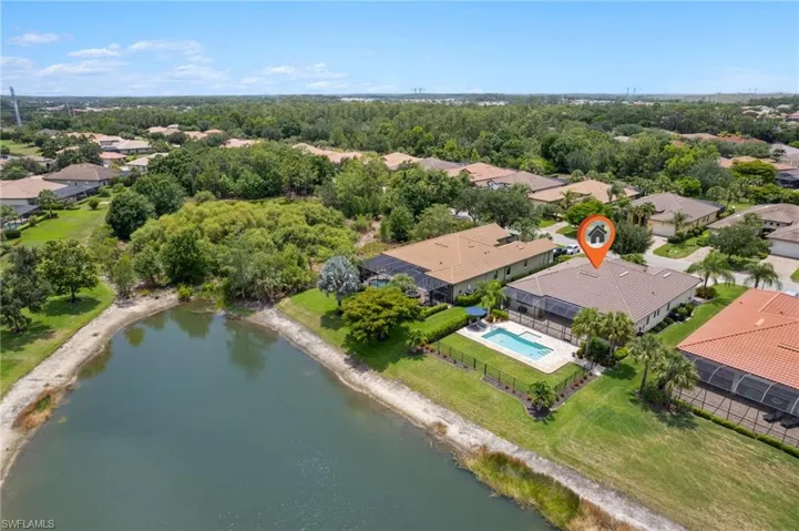 Aerial perspective of suburban area with a pool area and a large body of water