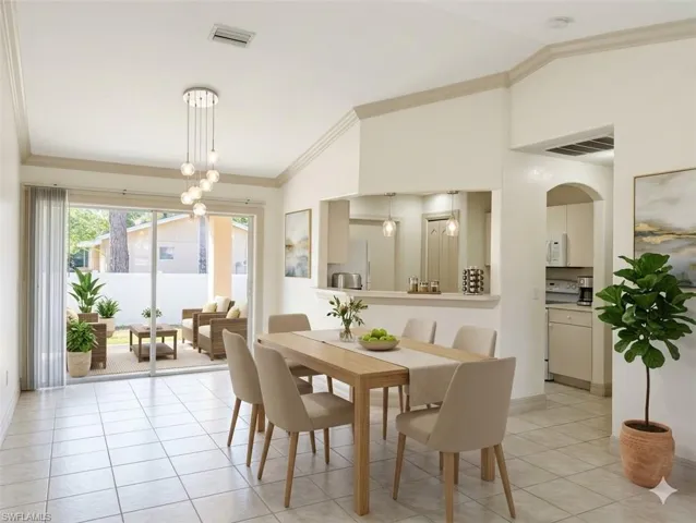 Virtual staged Dining area featuring ornamental molding, vaulted ceiling, light tile patterned flooring, a chandelier, and arched walkways