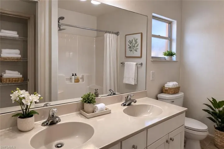 Virtual staged Bathroom featuring double vanity and curtained shower