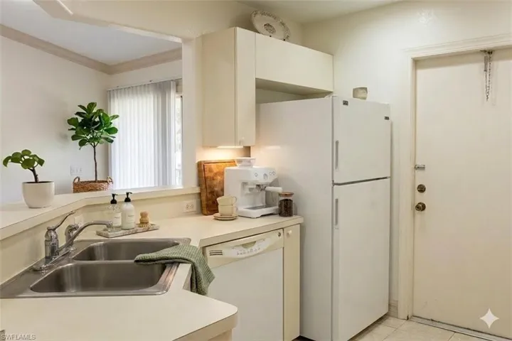 Virtual staged Kitchen featuring light countertops, white appliances, and white cabinets