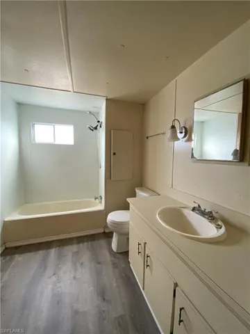 Full bath featuring bathtub / shower combination, vanity, and dark wood-style floors