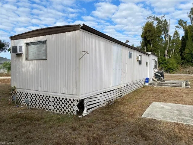 View of home's exterior with entry steps and a yard