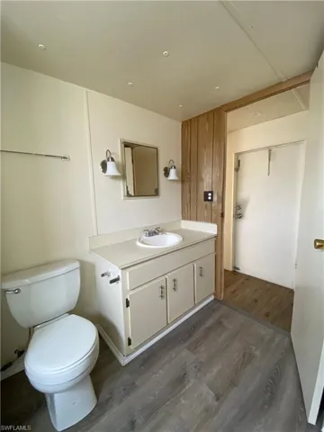 Half bath featuring dark wood finished floors and vanity