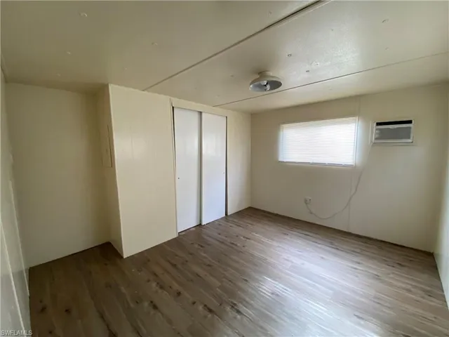 Unfurnished bedroom featuring wood finished floors and a closet