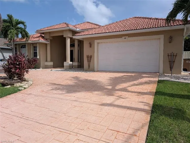 Mediterranean / spanish house featuring stucco siding, a tiled roof, decorative driveway, and a garage