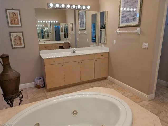 Full bathroom featuring a tub with jets and vanity