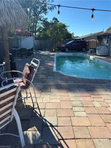 View of swimming pool with patio surround and a fenced backyard