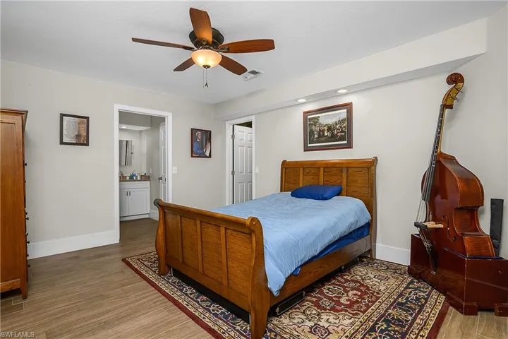 Bedroom with visible vents, baseboards, ceiling fan, and wood finished floors