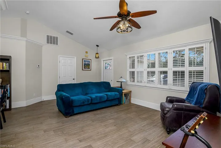 Living area featuring light wood finished floors, visible vents, baseboards, and a ceiling fan