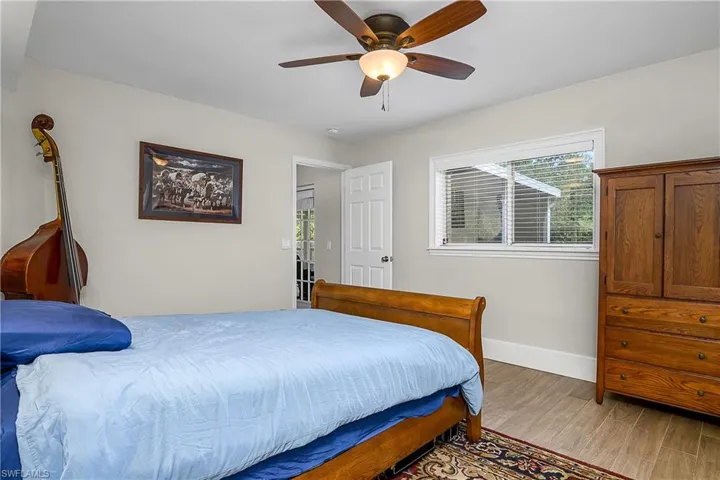 Bedroom with light wood-style floors, baseboards, and ceiling fan