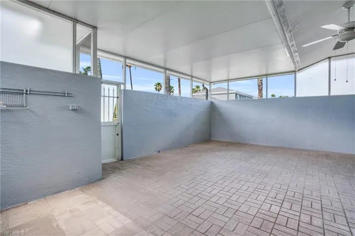 Unfurnished sunroom featuring a wealth of natural light and ceiling fan