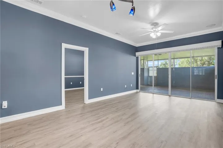 Empty room with crown molding, light wood-type flooring, and ceiling fan