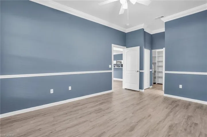 Empty room featuring ornamental molding, light hardwood / wood-style flooring, and ceiling fan