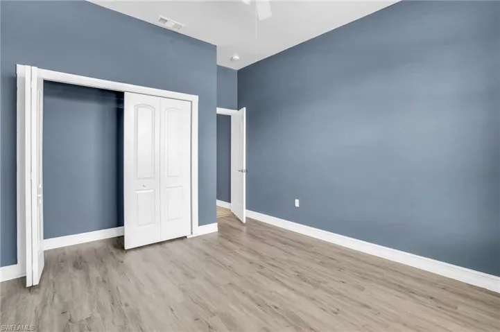 Unfurnished bedroom with light hardwood / wood-style floors, a closet, and ceiling fan