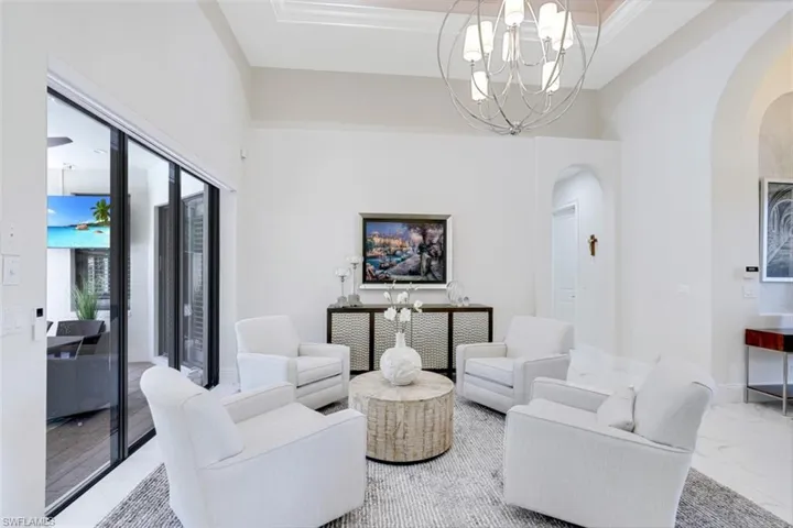 Sitting room featuring chandelier lighting, tile floors and a high ceiling