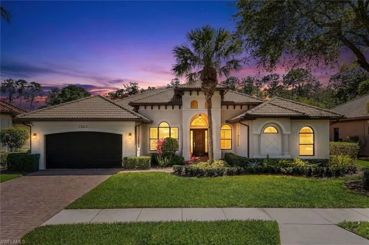Mediterranean / spanish house featuring stucco siding, a garage, decorative driveway, a tile roof, and a front lawn