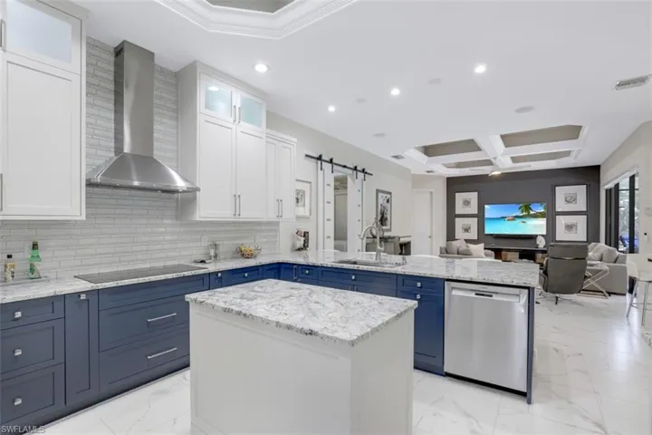 Two tone Kitchen with a barn door, dual tone cabinetry, a peninsula, glass insert cabinets, and stainless-steel dishwasher with Bosch appliances.
