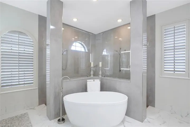 Double walk in shower, a freestanding bath, and recessed lighting